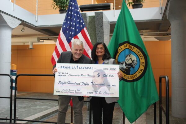 Community Roots CEO Chris Persons accepting a $850,000 check from Congresswoman Pramilla Jayapal in October 2024.